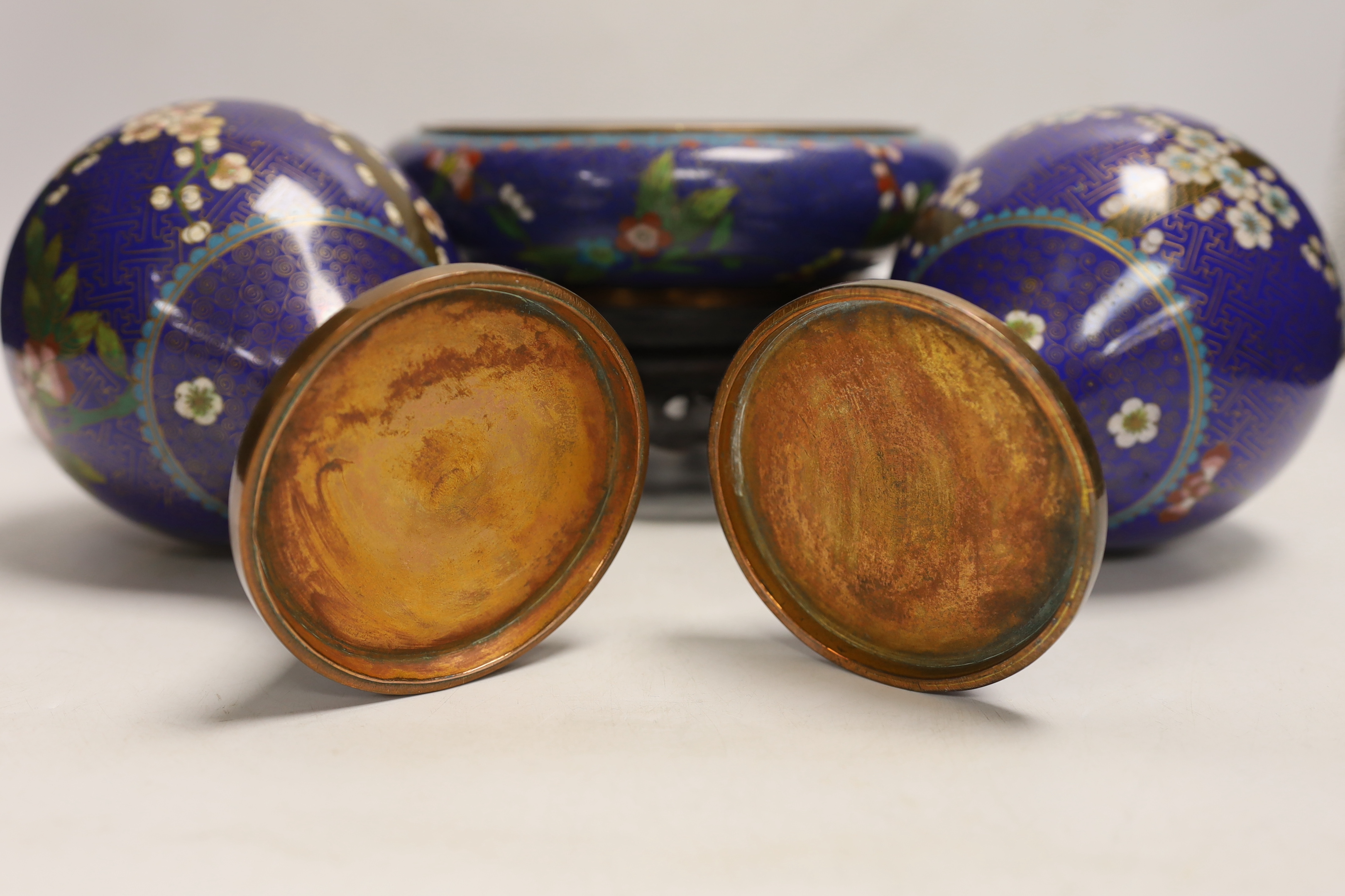 A pair of early 20th century Chinese cloisonné enamel jars and covers, together with a similar bowl and wood stand, largest 20cm high